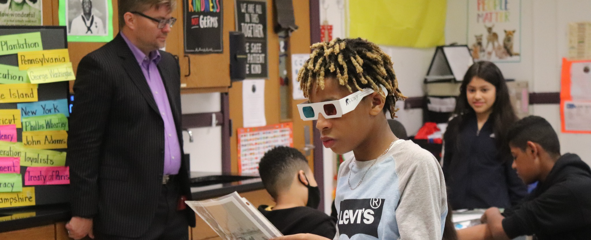 Middle school student looks at sheet while wearing 3D glasses