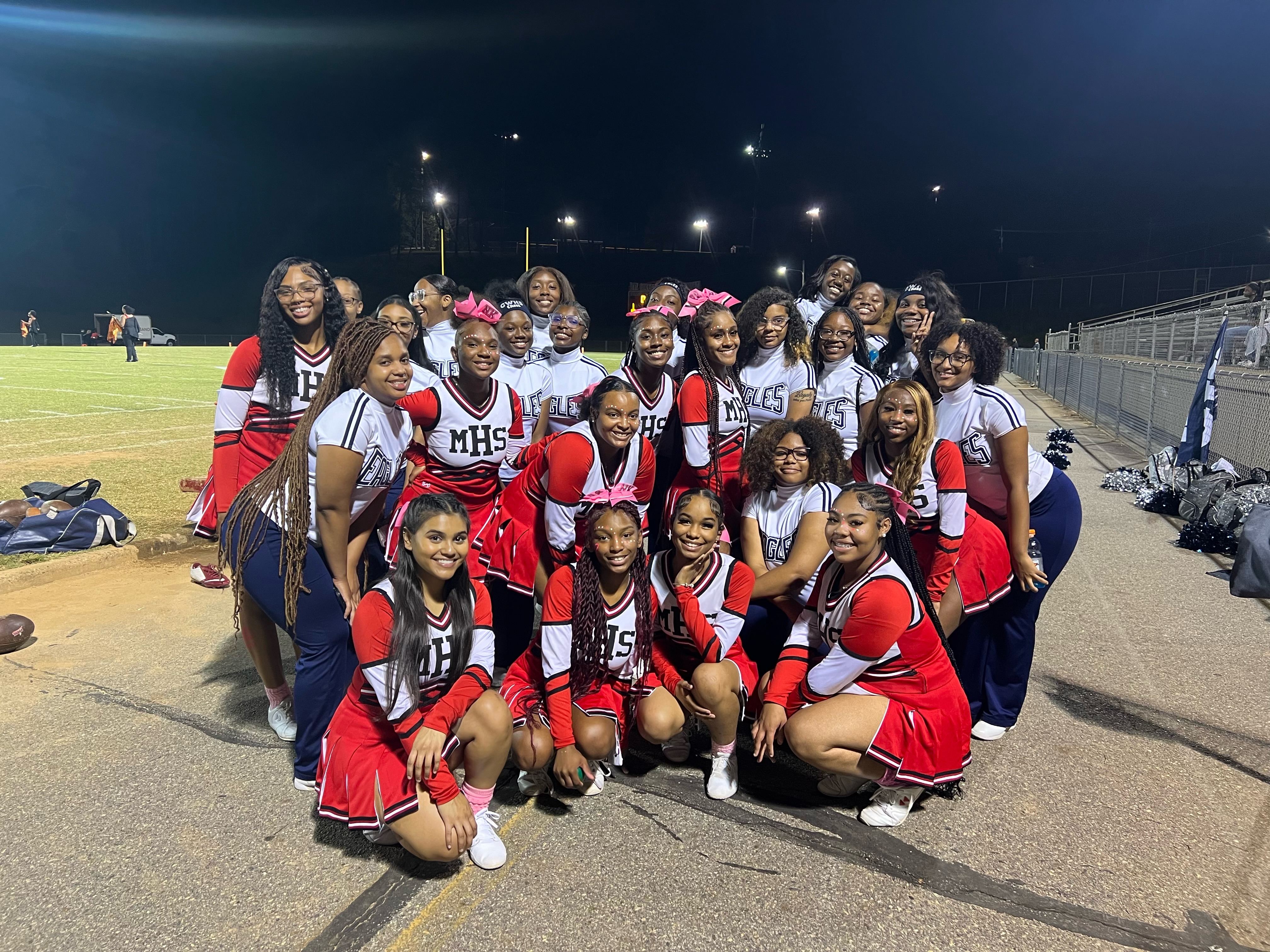 MHS Cheerleaders pose for a group photo by the football field