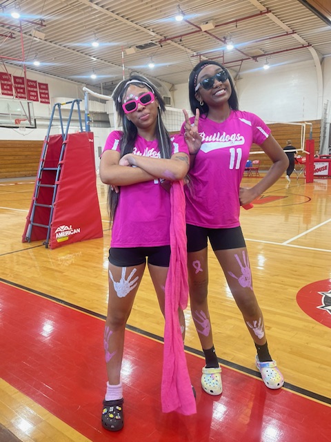 Two high school students pose on the volleyball court