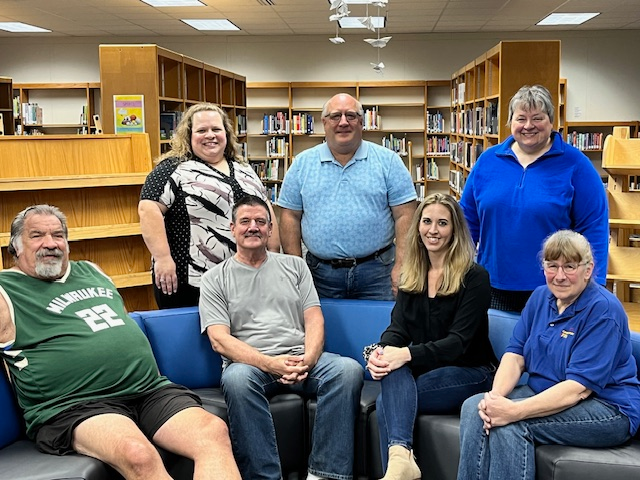 Picture of Board of Education Members Keith Peters, Jim Ninnemann, Jessica Strand, Deb Senn, Sharon Gazzola, Mike Weiss and Maureen Koch seated in the library