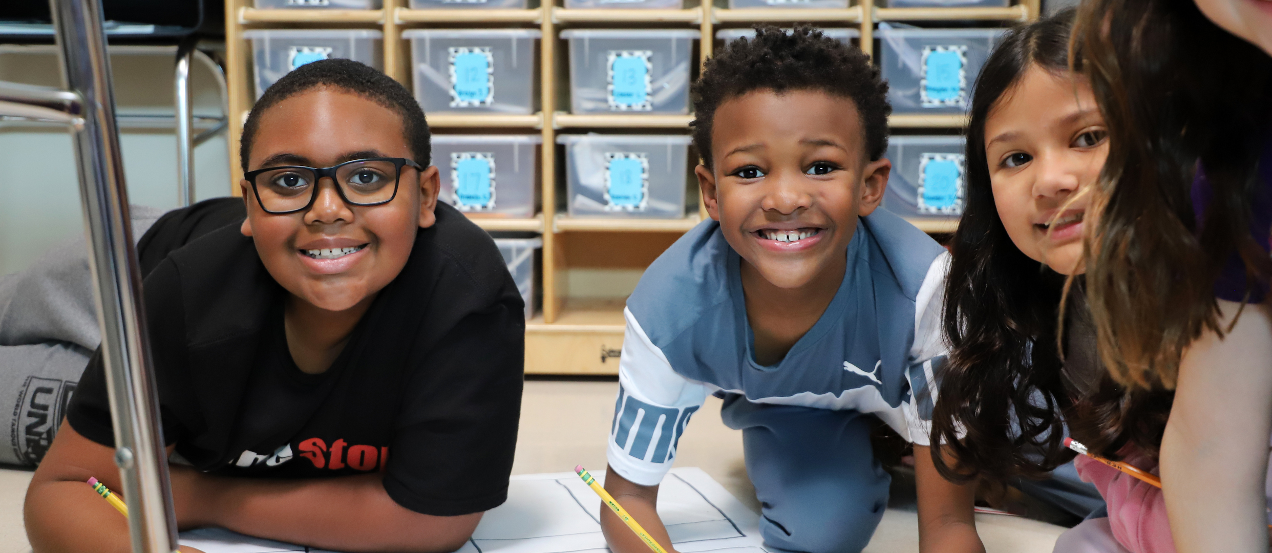 students working on a science project on the floor