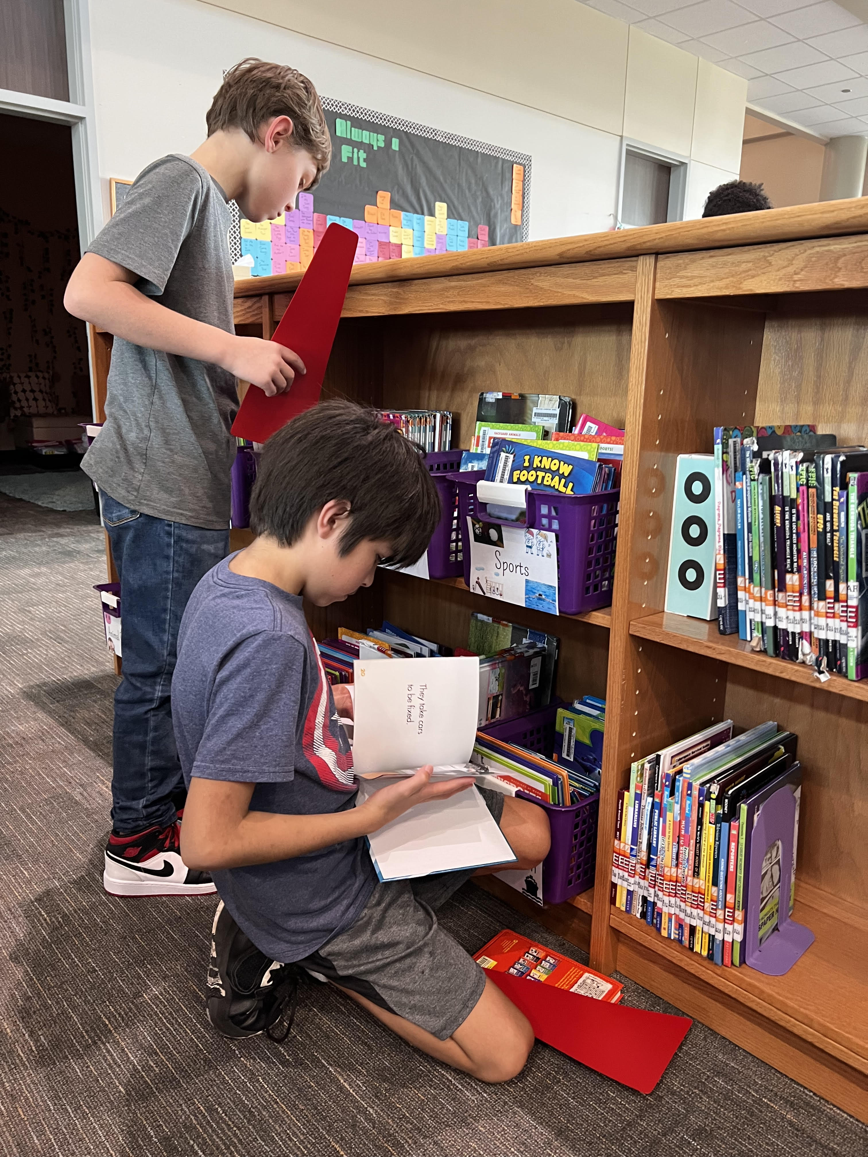 STUDENTS CHECKING OUT LIBRARY BOOKS