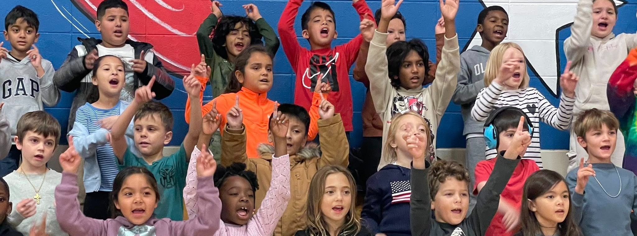 Students cheering in the gym stands