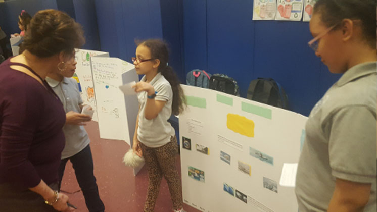 students presenting their project to a teachers