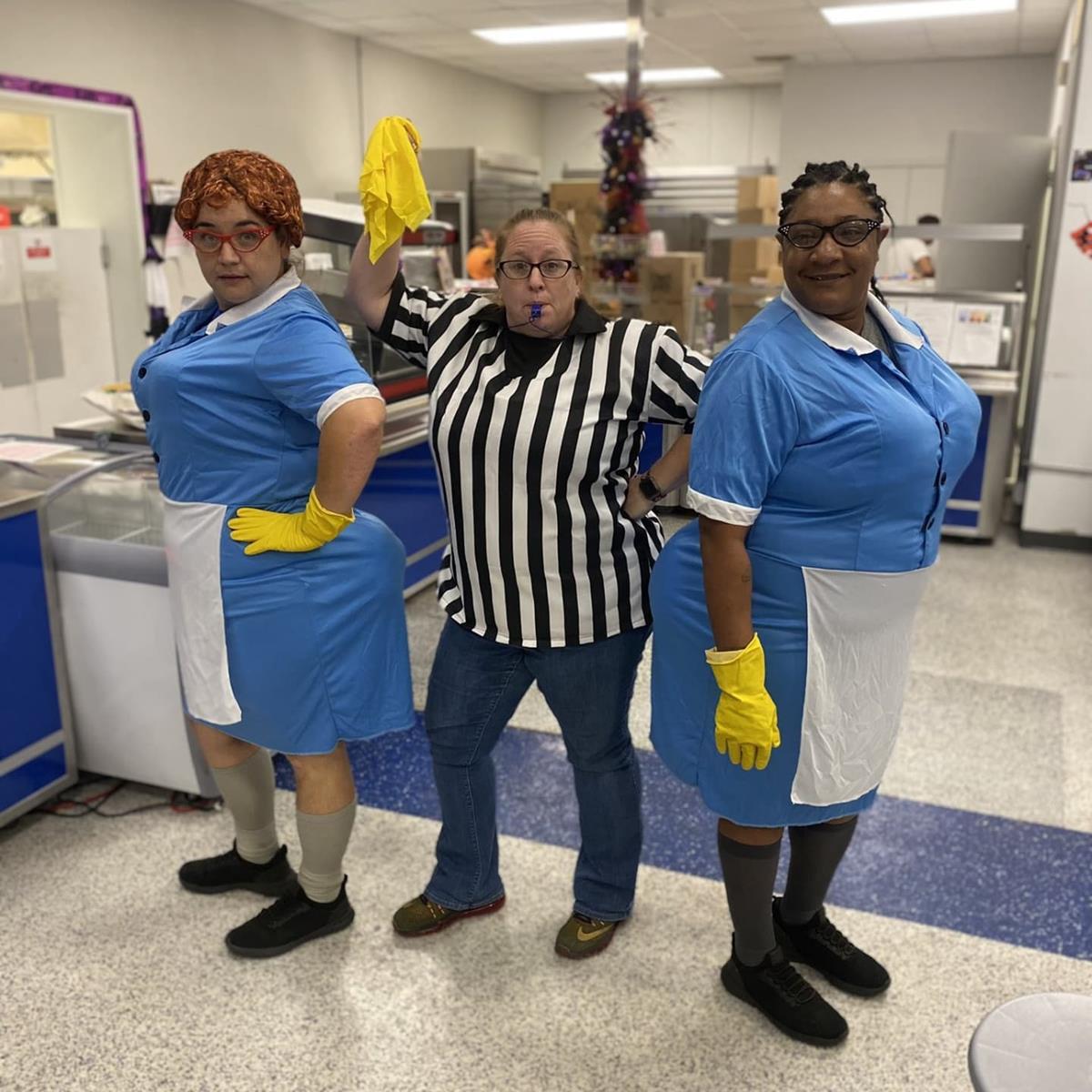3 staff members standing in the cafeteria posing