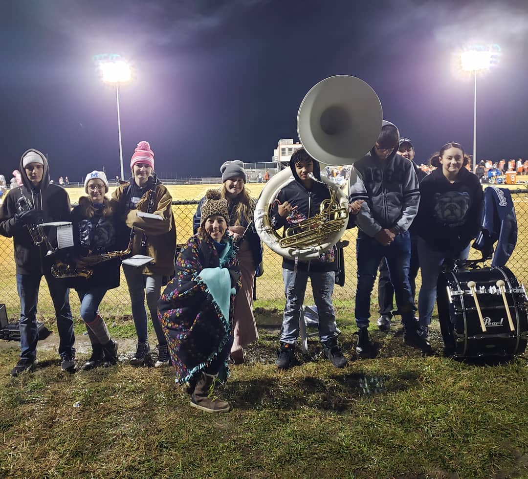 Band students taking a picture together at a game.