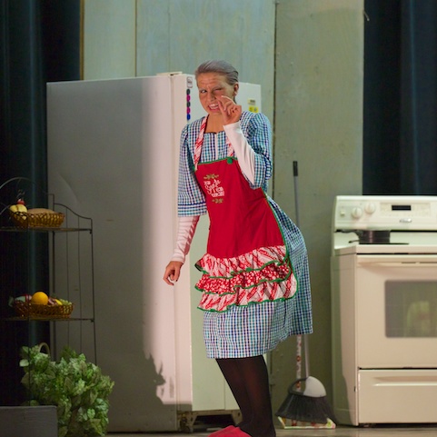 Character from play with a blue dress and red apron on.