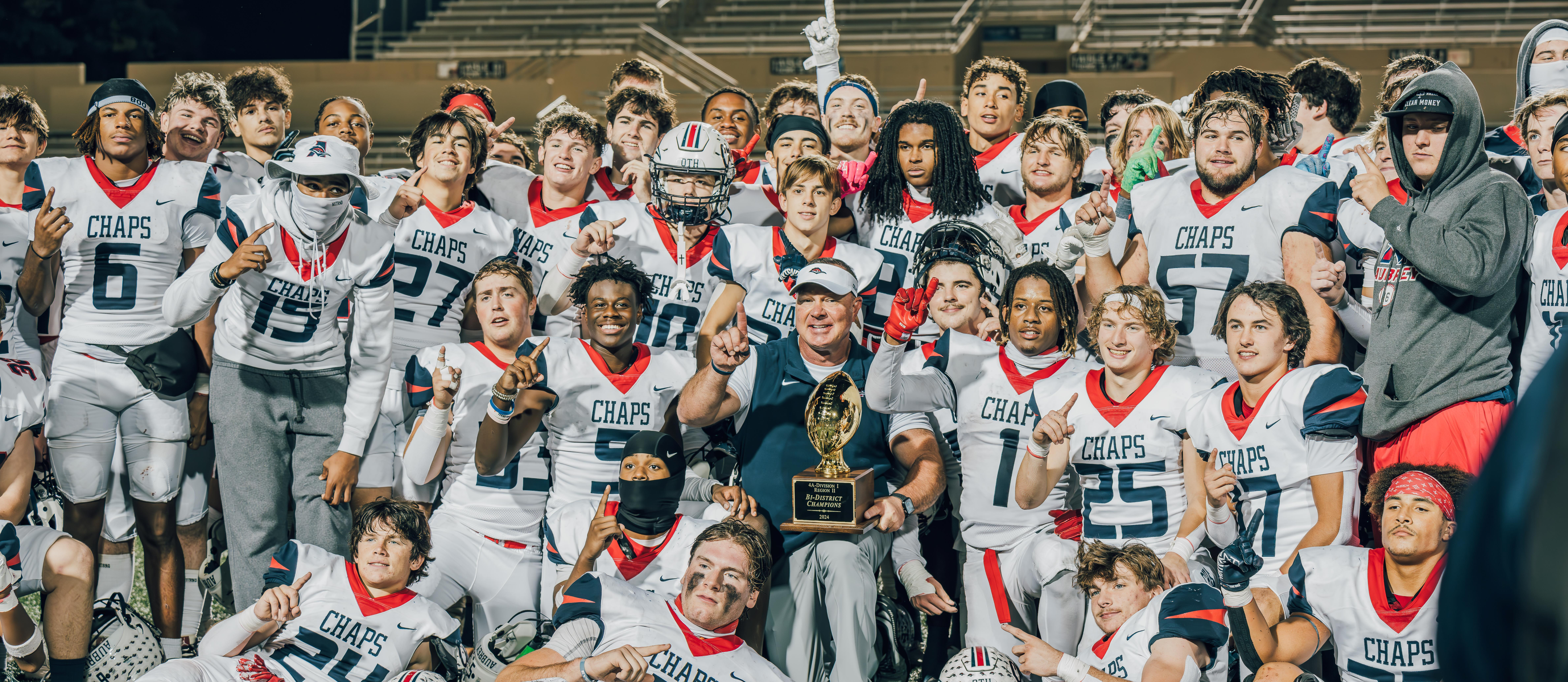 Aubrey High School football team group photo with 2024 bi-district champions trophy