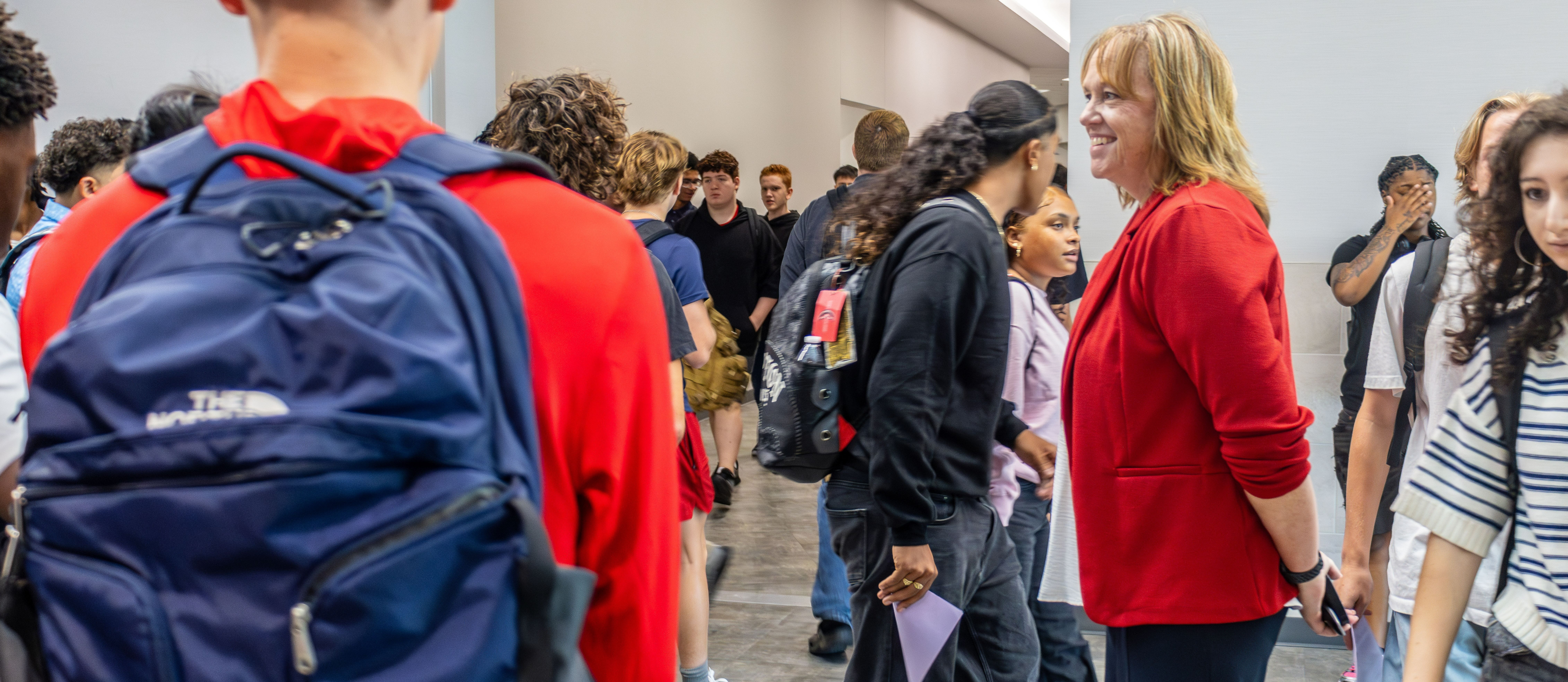 First Day of School photo in high school hallway as superintendent watches on