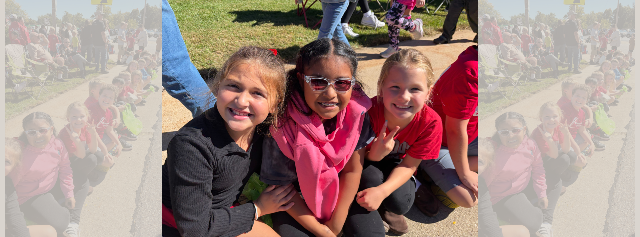 three female students smiling at the camera during the homecoming parade