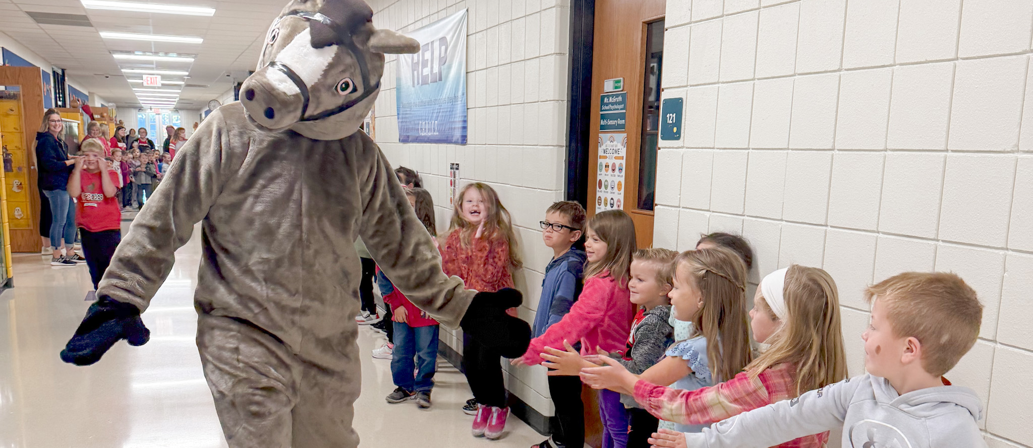 Kindergarteners giving the pony mascot high fives