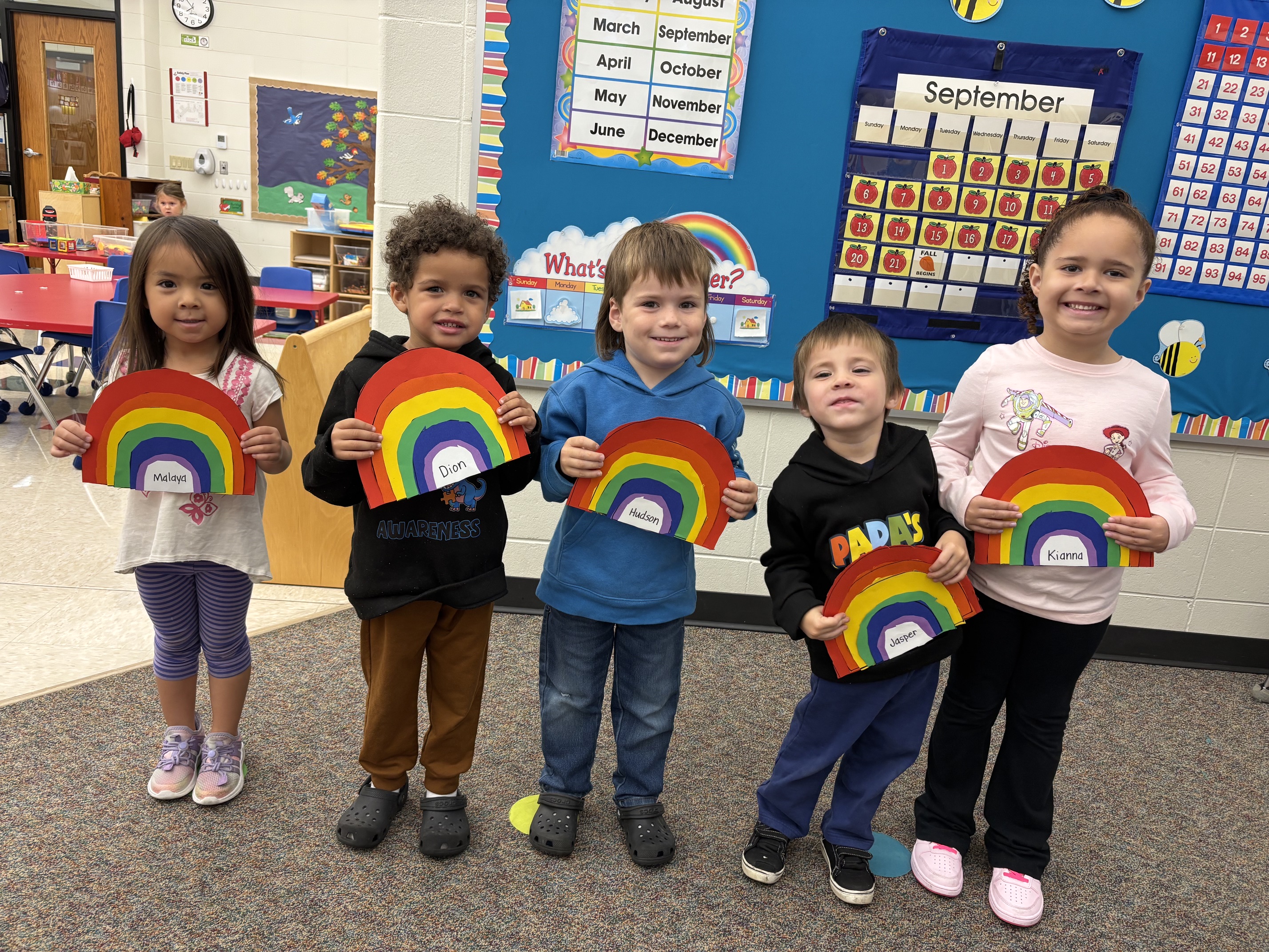 4K students pose with rainbow art projects
