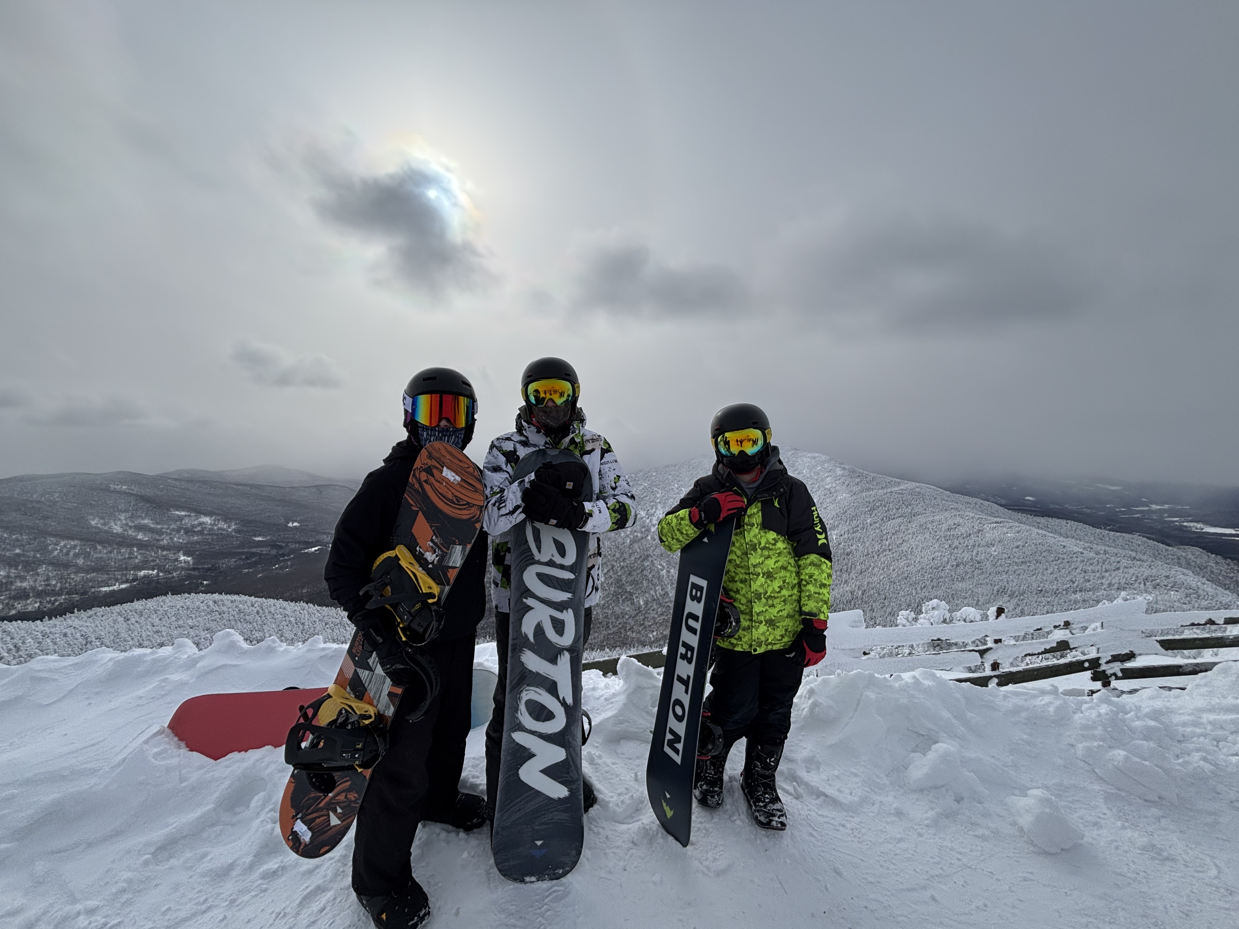 three snowboarders posing at the top of Jay Peak