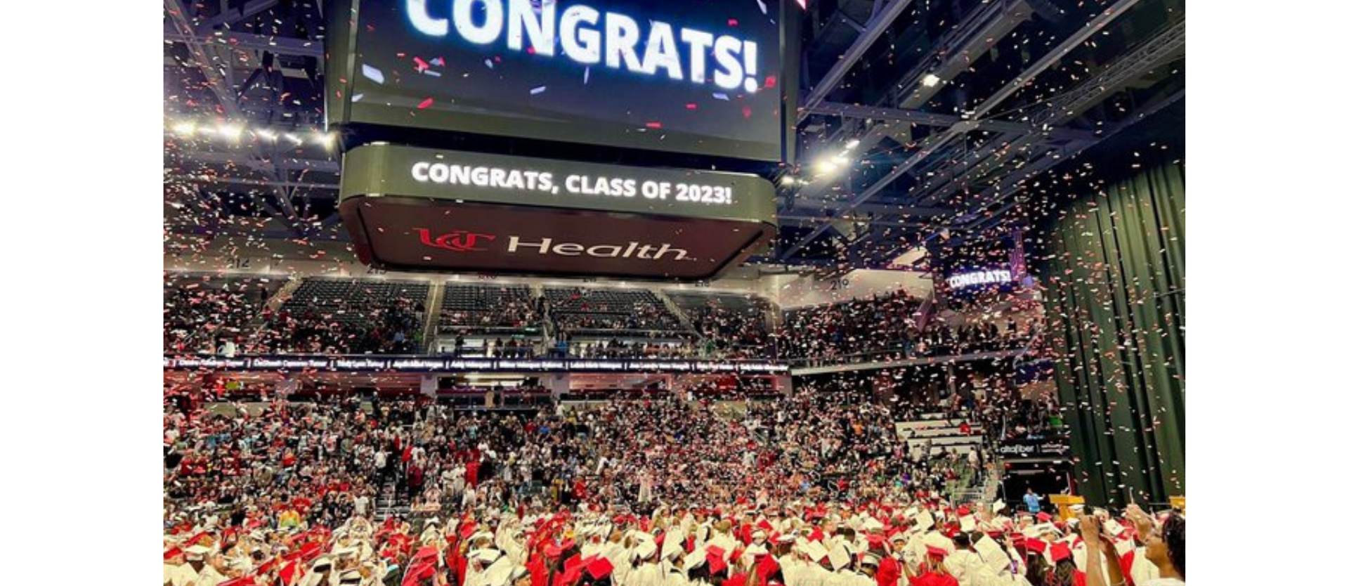 Congrats sign at graduation with students under and confetti
