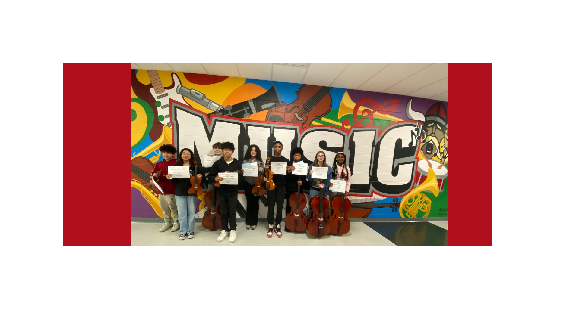 Photo of the PCMS Jr Solo and Ensemble Orchestra Students with instruments in front of the new MUSIC Mural