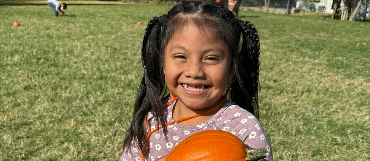 student wtih pumpkin