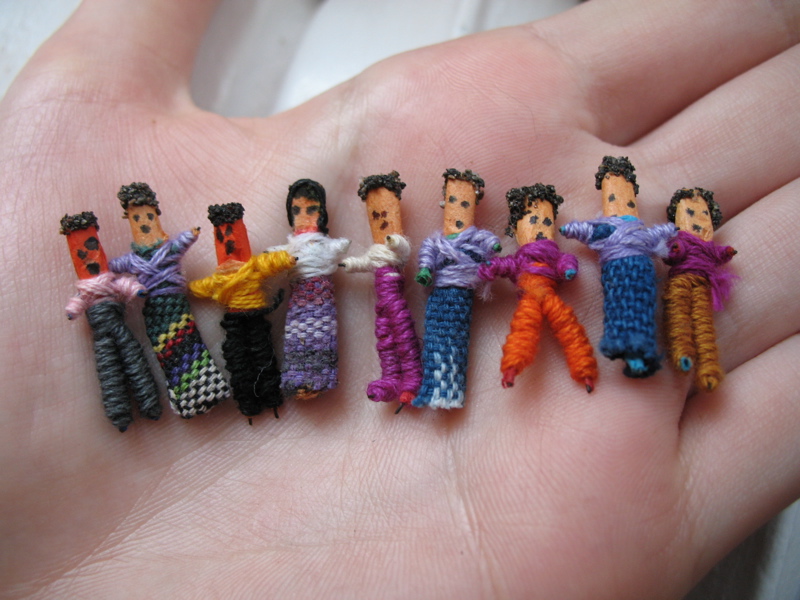 Photo of little dolls in the palm of a hand.