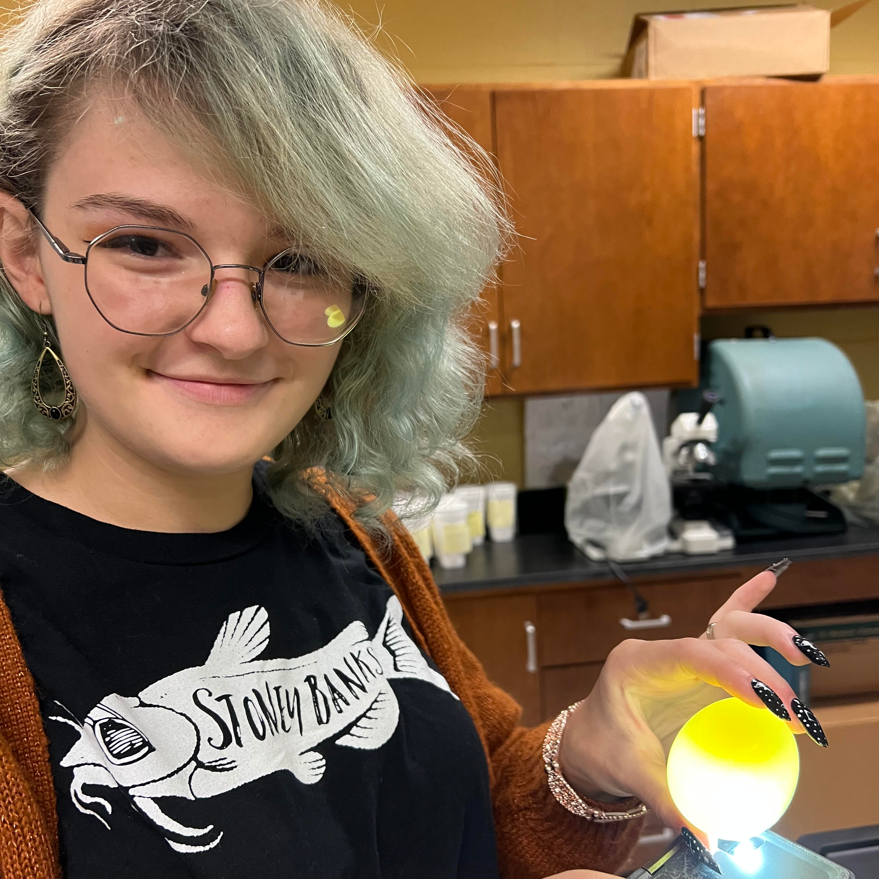Emily Amerman (10th) is displaying a chicken egg after dissolving its shell with acetic acid. The goal of this Biology lab was for students to observe how eggs, like cells, respond to different solutions to shrink, expand, or stay the same.