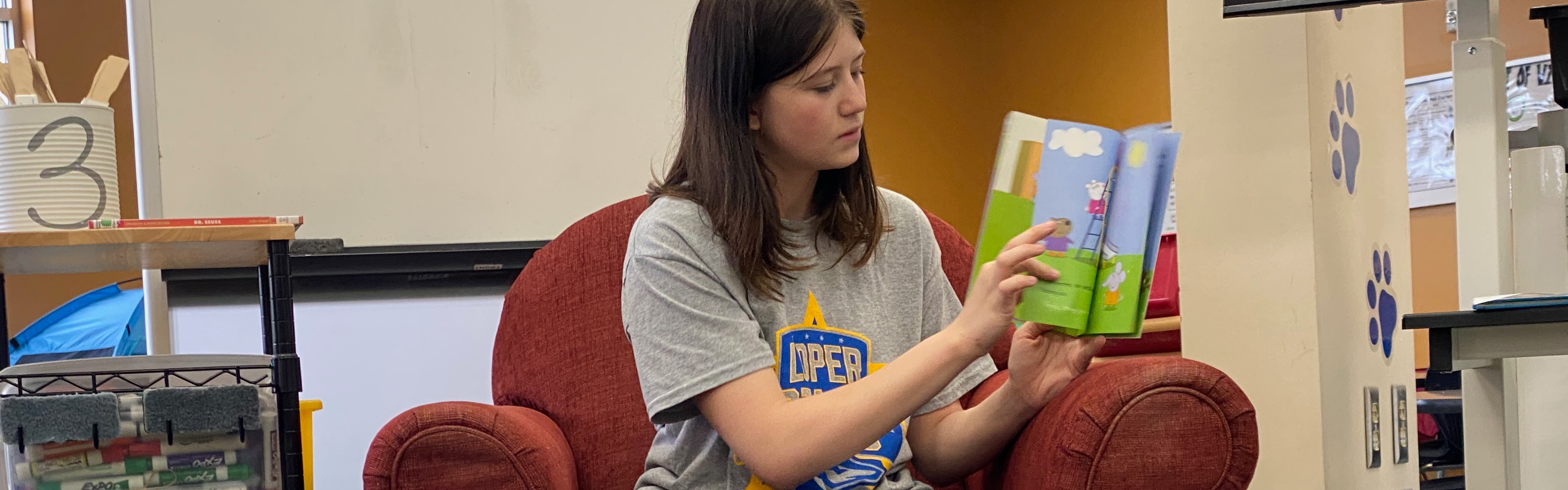 High school student reading to the elementary