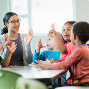 students gathered around the teacher laughing and learning