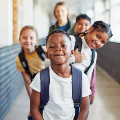 5 kids lined up in front of the camera smiling and posing for the camera