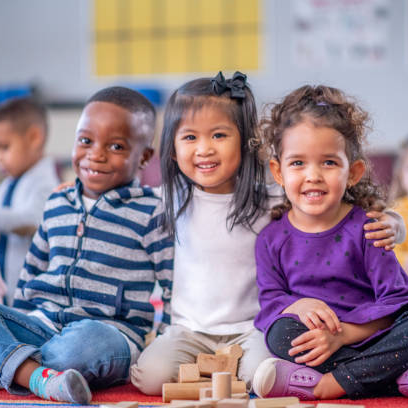 three kids sitting next to each other and smiling for the camera