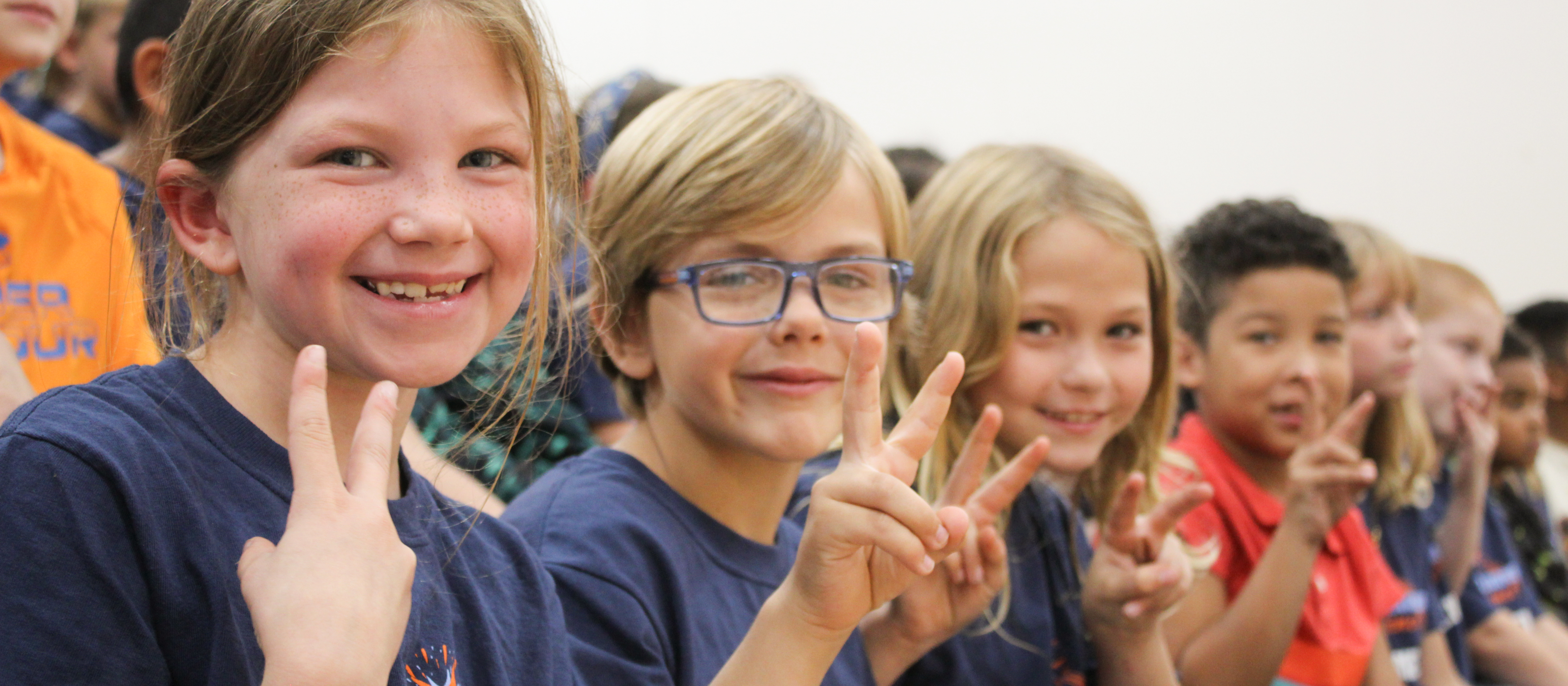 Students holding up two fingers to indicate "two"