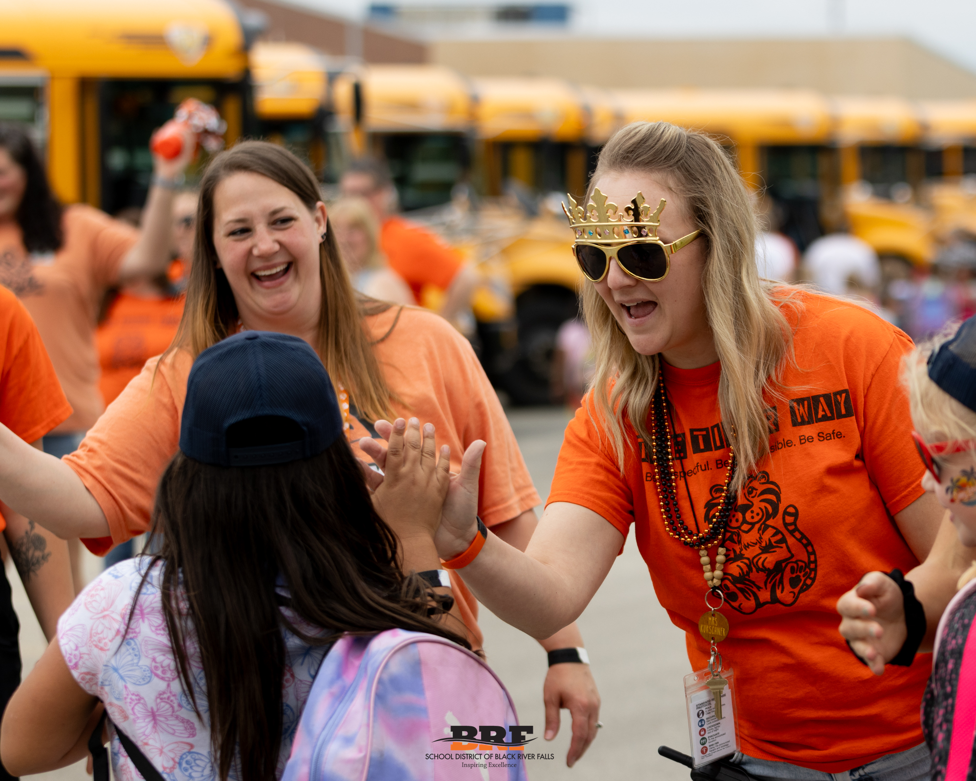 Staff member high-fives student.