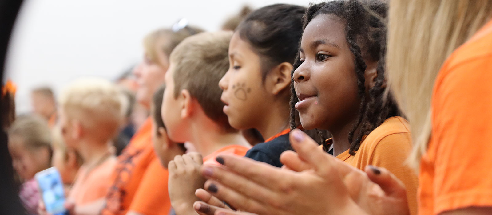 Girl claps at pep assembly