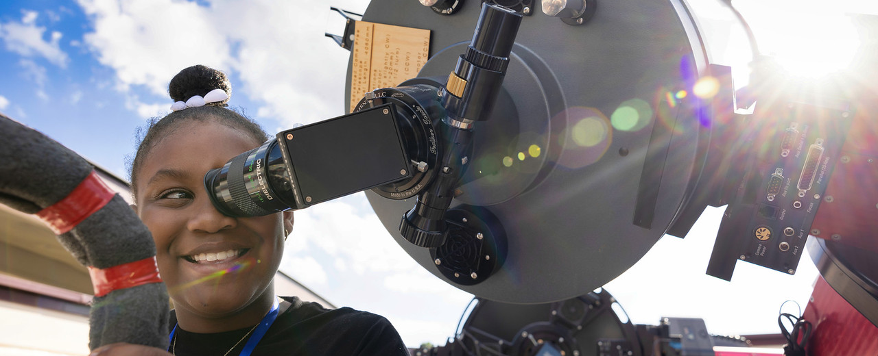 Student looking through telescope