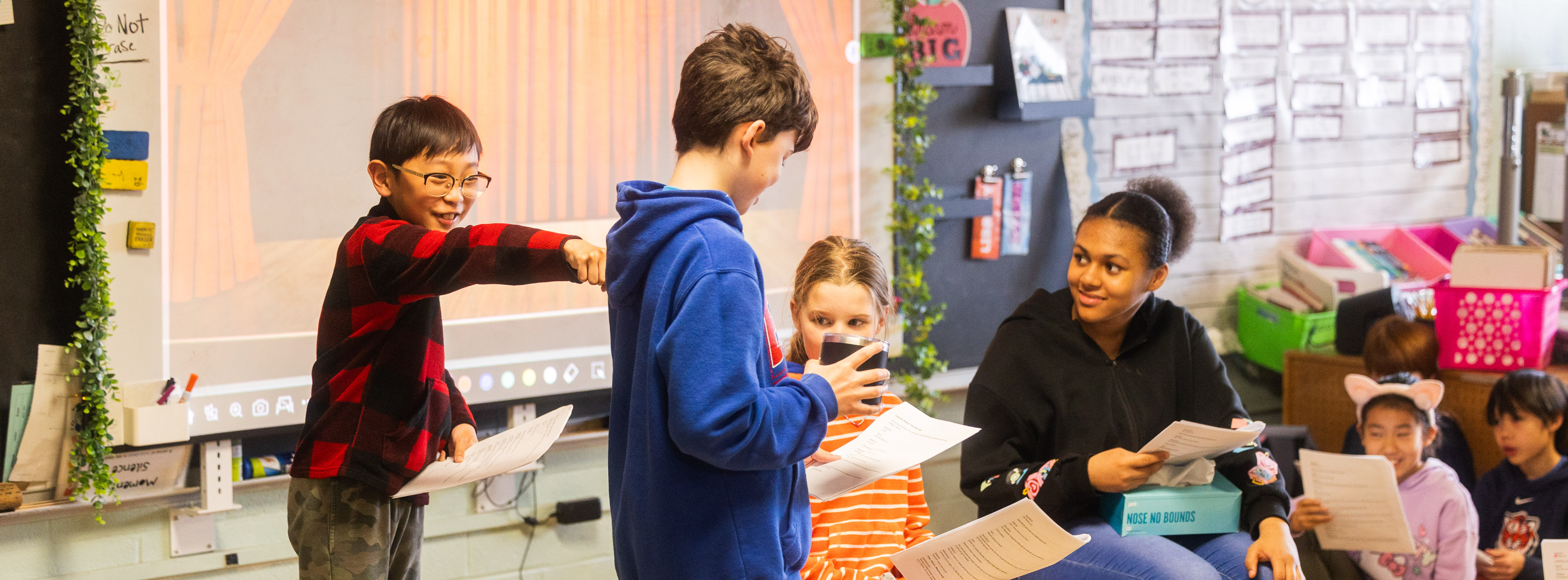 Students acting out a play at the front of a classroom