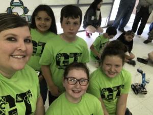 four kids with green tshirts and the teacher