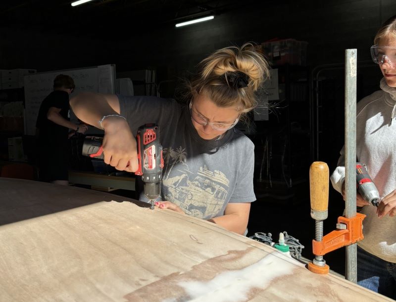 Hailey uses the drill on the new boat