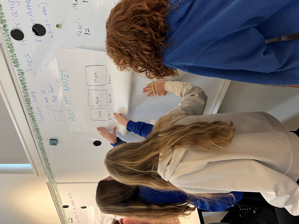 6th grade group works on a math problem at the white board