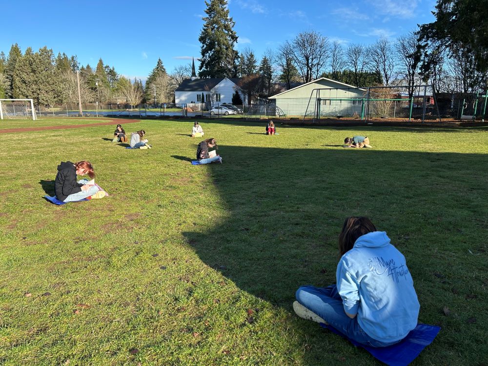 Middle schoolers journaling in the school field