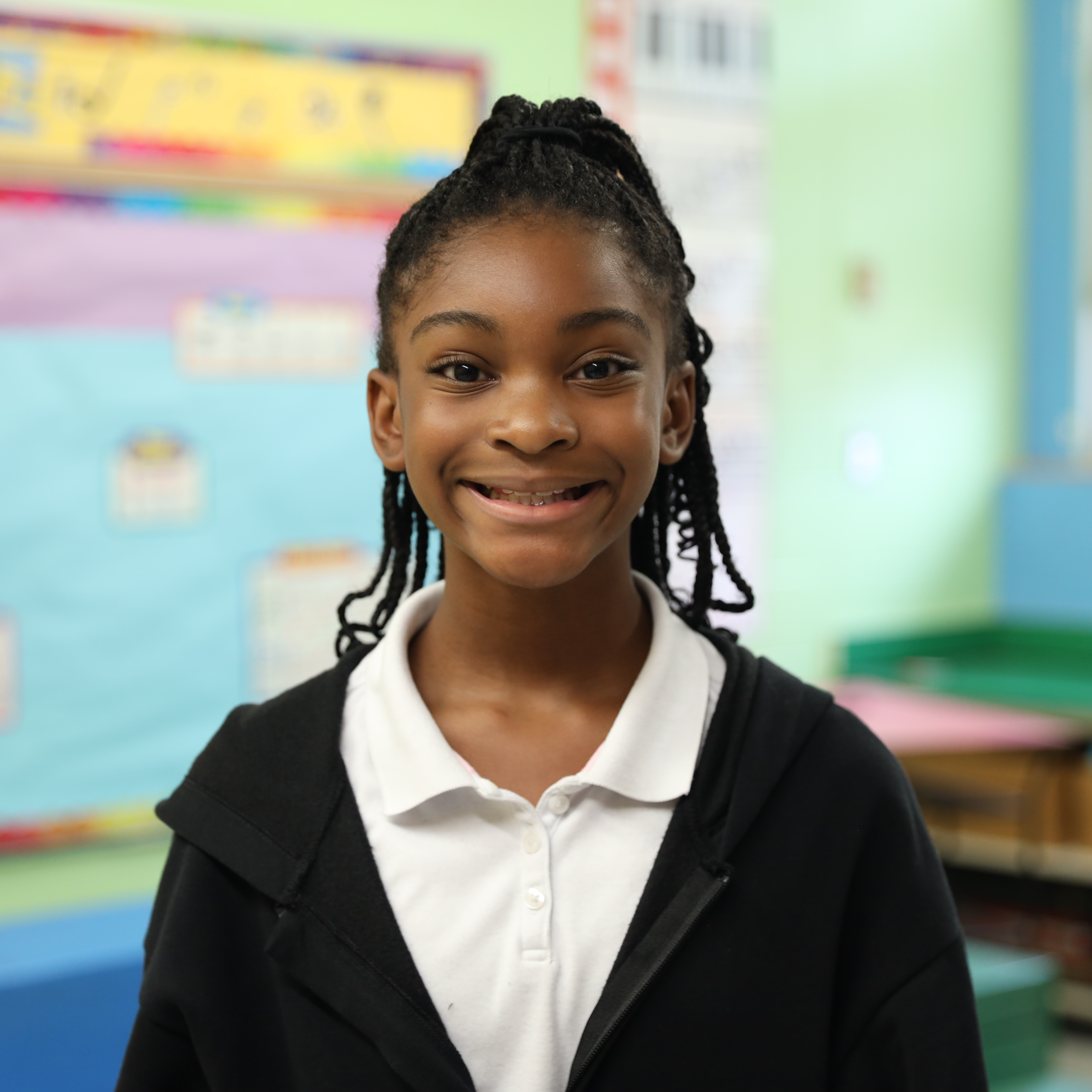 Cambria Fuller is smiling and posing for a photo inside of Warrenton's colorful music classroom.