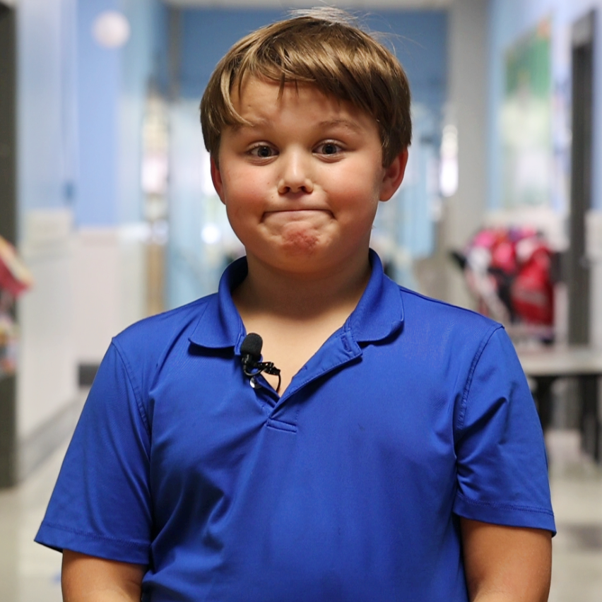 Travis Hamilton is smiling for a photo while standing in the hallway at Redwood Elementary School.