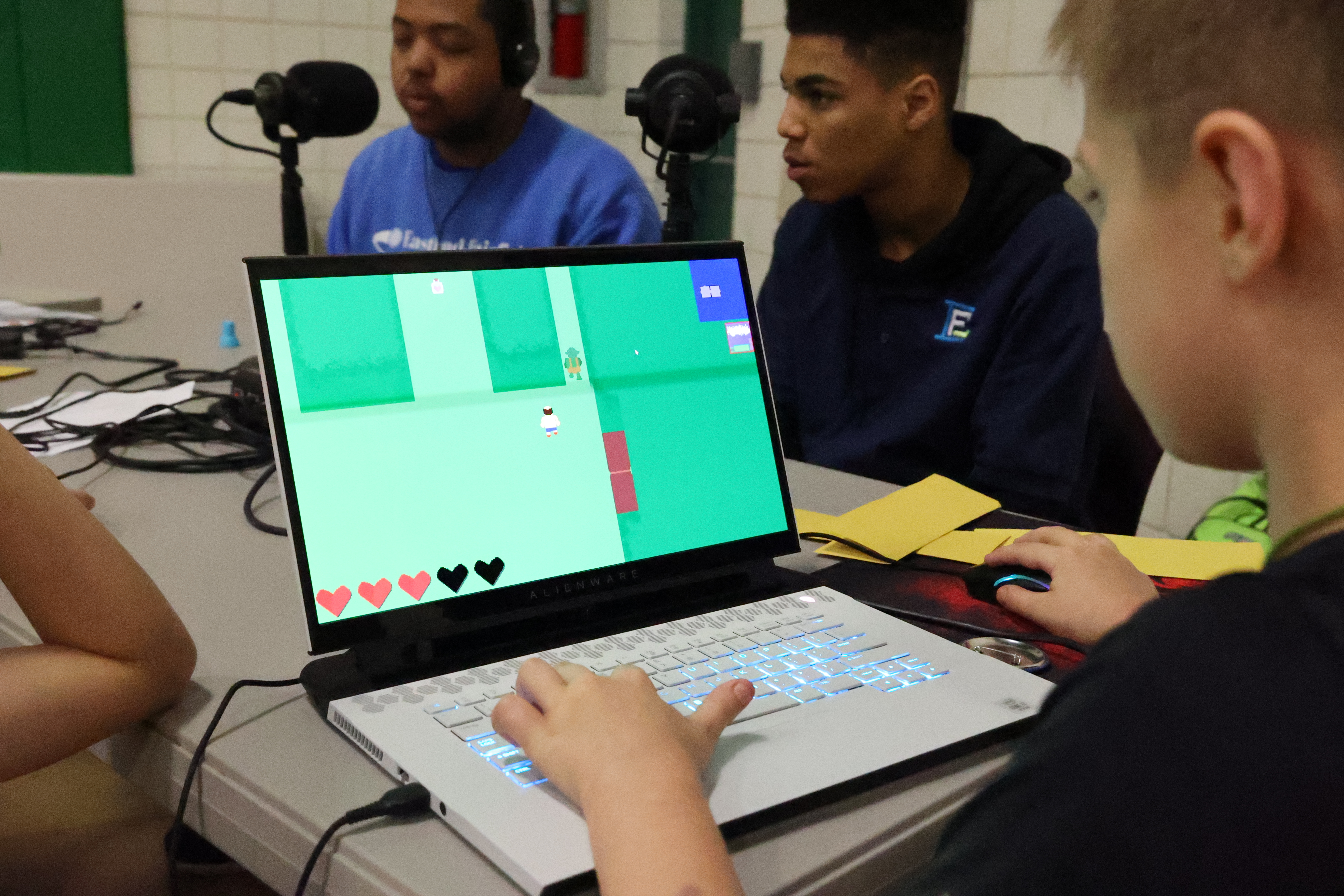 A young male student is playing a game on a laptop created by EFCTS students.
