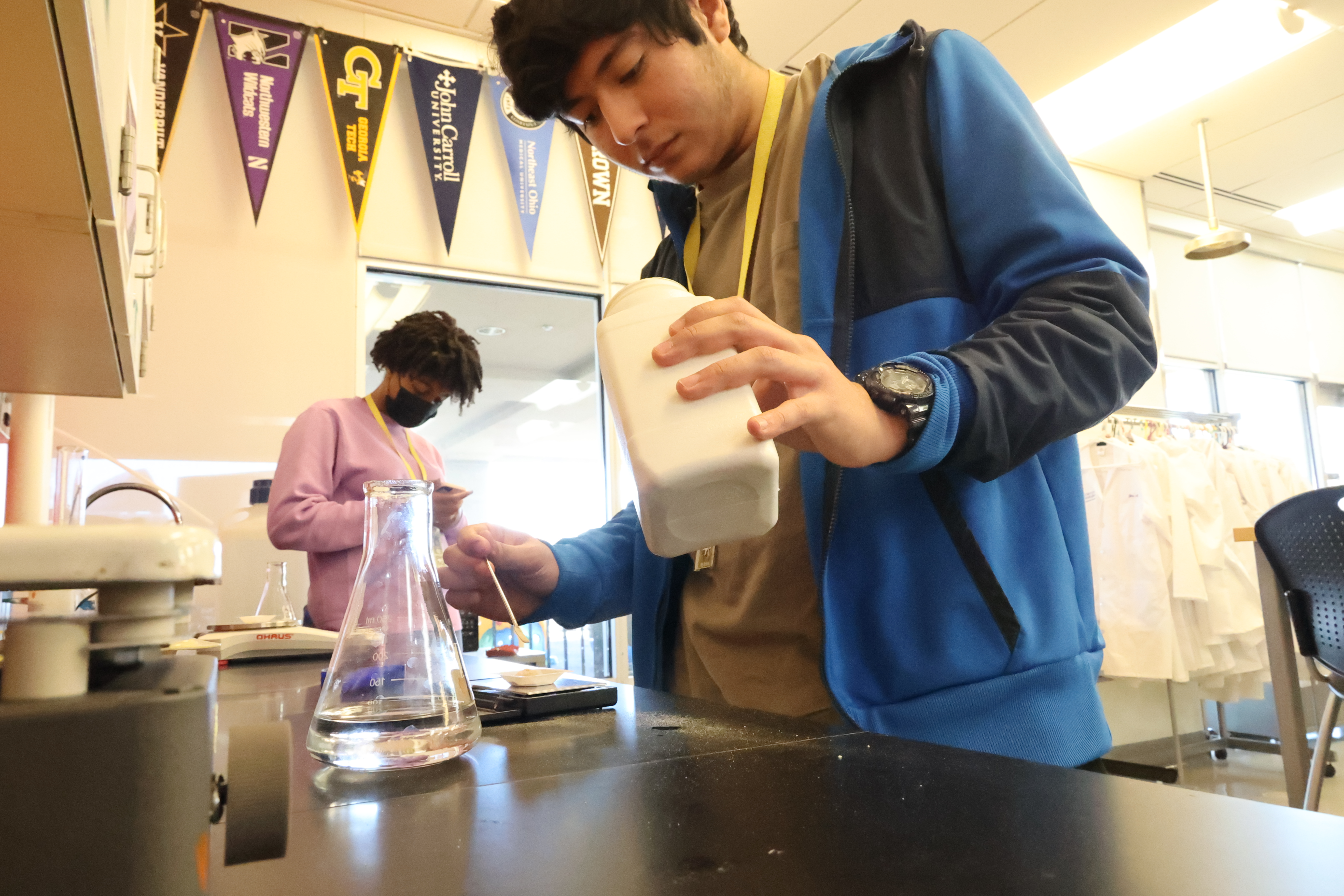 A male student mixing and weighing powder