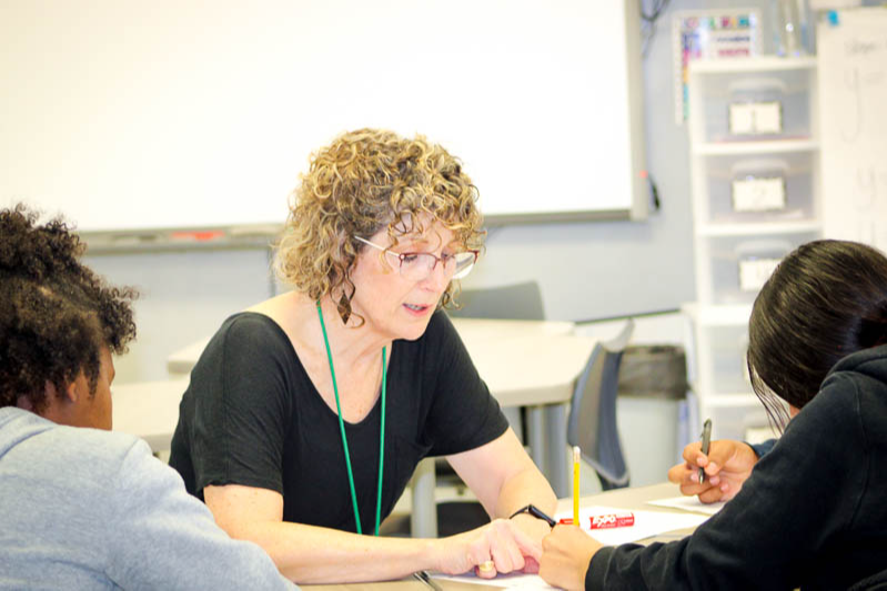 Karen Peyton, HMS teacher, working with two students in the classroom