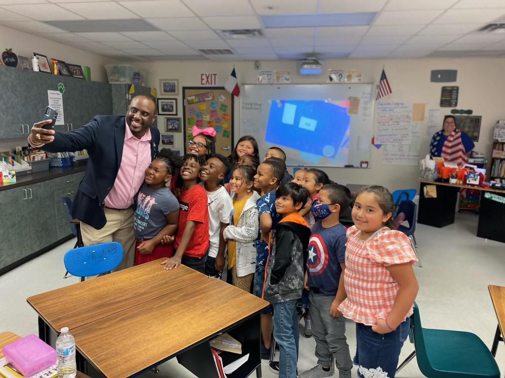 superintendent posing for a selfie with children