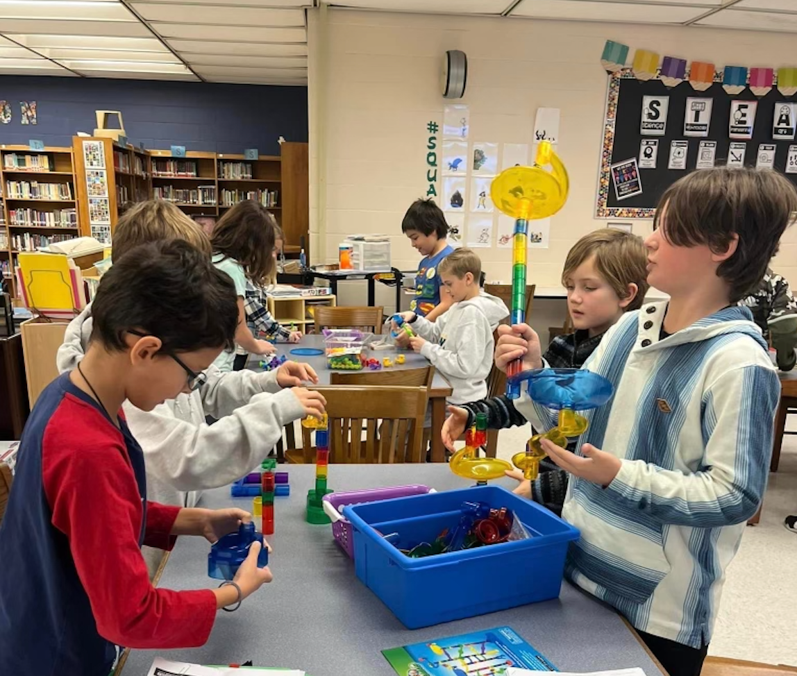 Students working in the library on a STEM challenge.