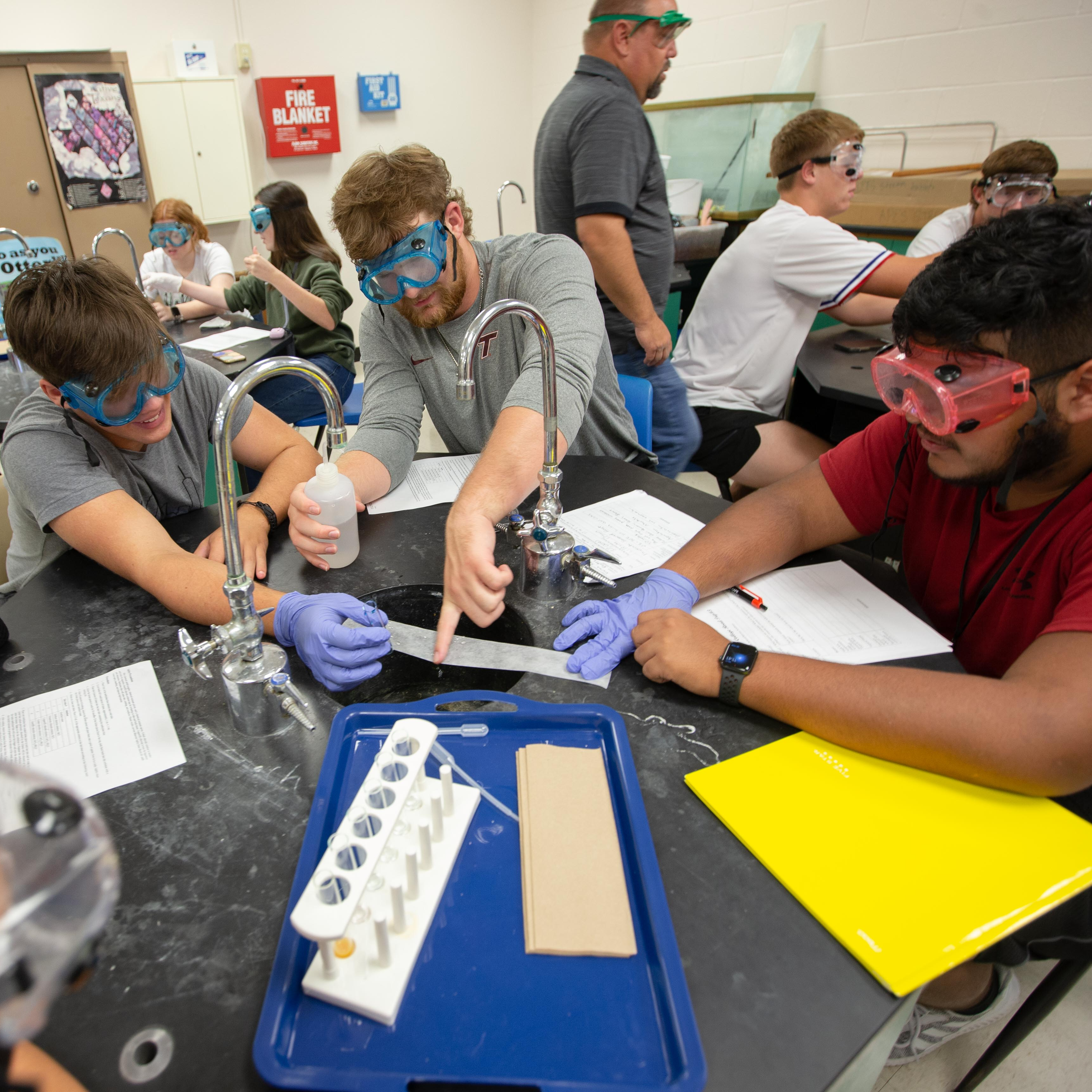 3 high school boys working  in science lab
