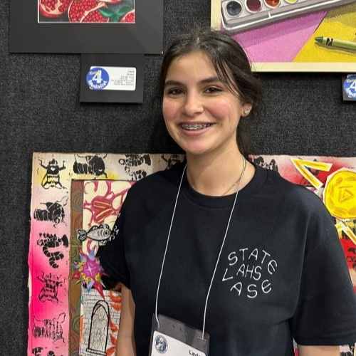girl wearing black shirt standing in front of art projects