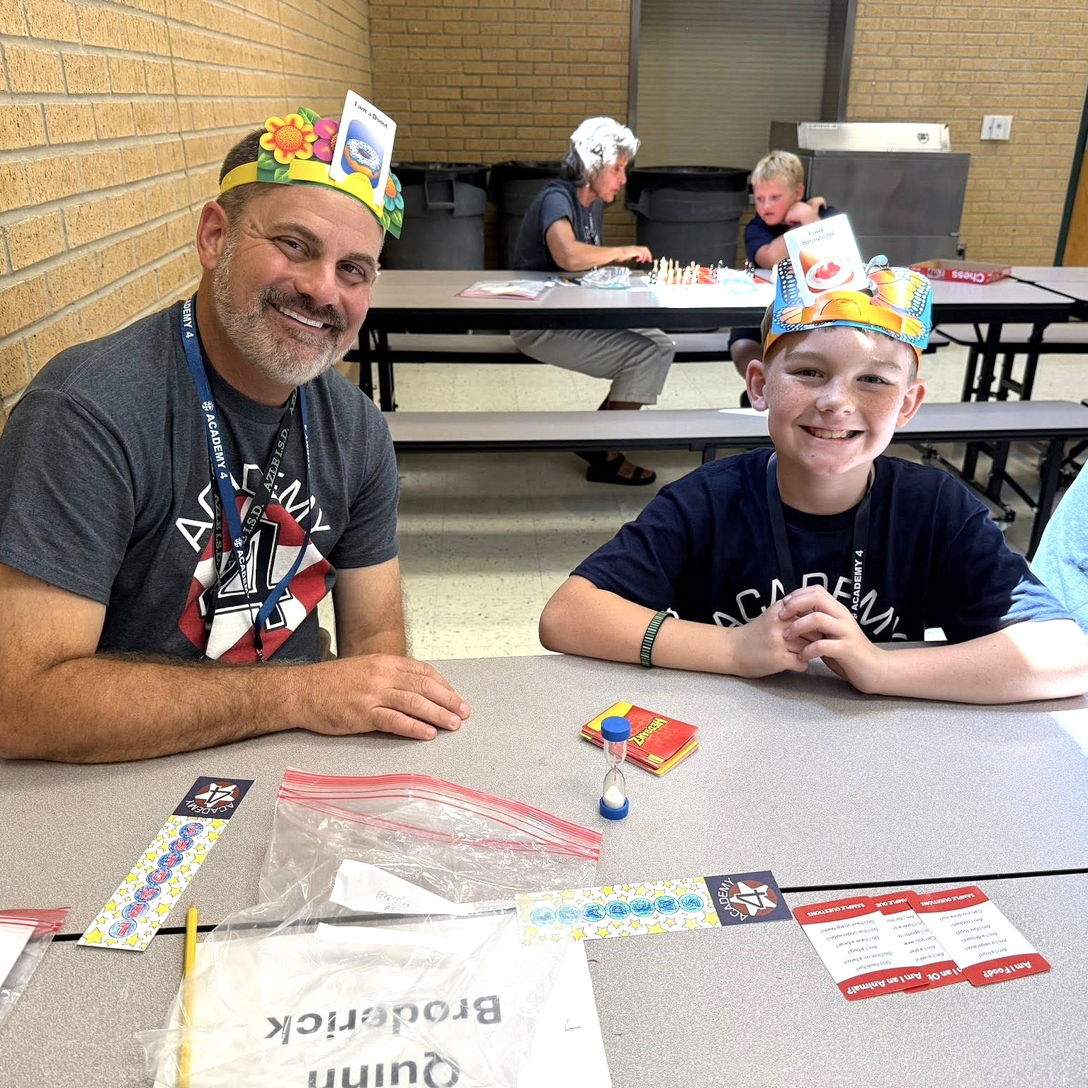 Mr. Smith with boy in cafeteria playing games with Academy 4