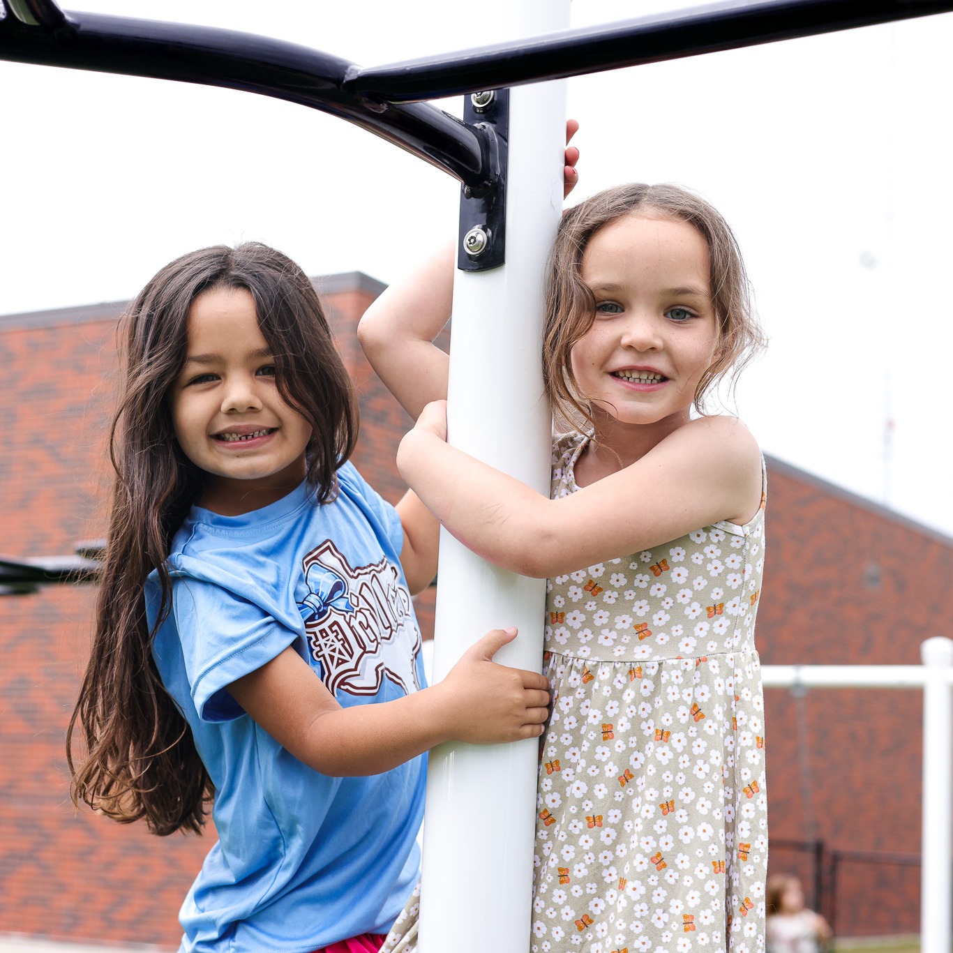 two elementary school girls playing on playground