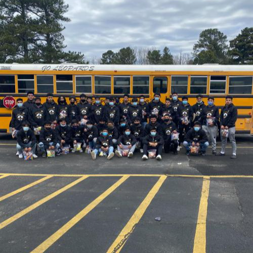 soccer team group picture in front of school bus