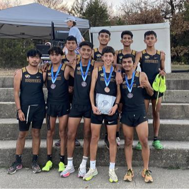 cross country team group picture outside with medals