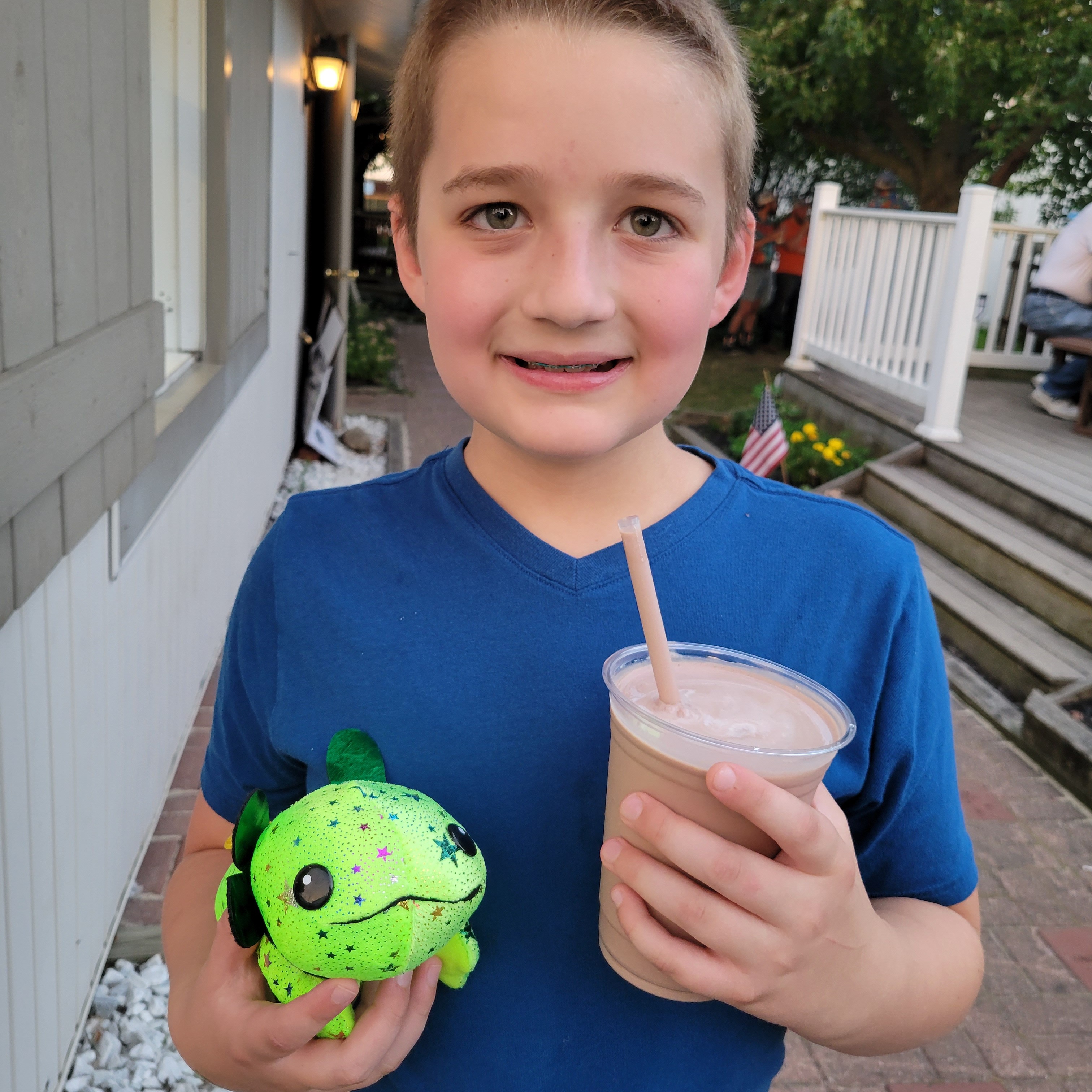 Jaxon P. smiles, holding a milkshake at the Geauga County Fair. 