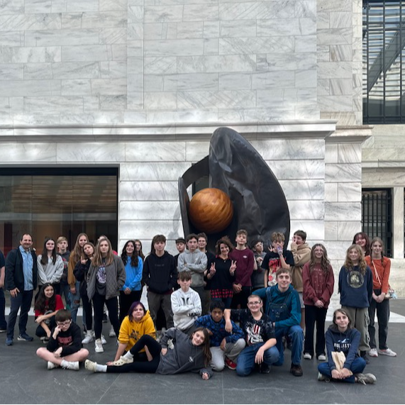 Students in 8th Grade pose in front of a statue at the Cleveland Museum of Art. 